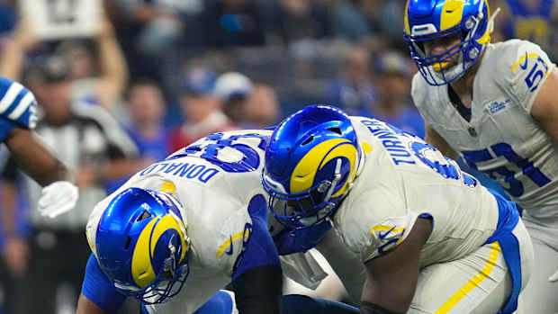 Indianapolis Colts quarterback Anthony Richardson (5) falls down and is tackled by Los Angeles Rams defensive tackle Aaron Donald (99) and defensive tackle Kobie Turner (91) during the first half of the game Sunday, Oct. 1, 2023, at Lucas Oil Stadium in Indianapolis.